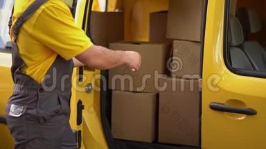 <strong>快递</strong>员把<strong>箱子</strong>放进黄色的货车里。